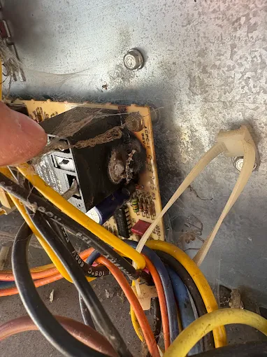 Professional electrical component repair and maintenance for Salem AC systems DiMartino's HVAC technician working on AC system electrical components and wiring during repair service in Salem Oregon