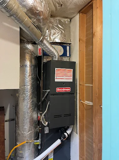 Professional HVAC technician installing Goodman furnace system Salem Oregon basement installation